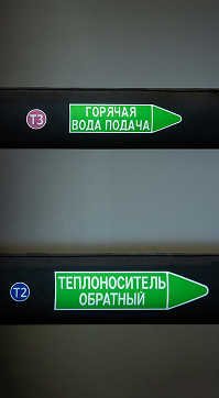 Два трубопровода с зелеными стрелками «Горячая вода подача» и «Теплоноситель обратный» с круглыми наклейками «Т3» и «Т2»